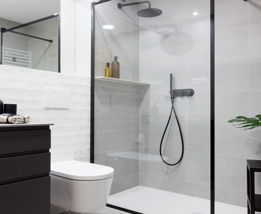 UN BAÑO DE DISEÑO MODERNO CON DUCHA EN BLANCO Y NEGRO